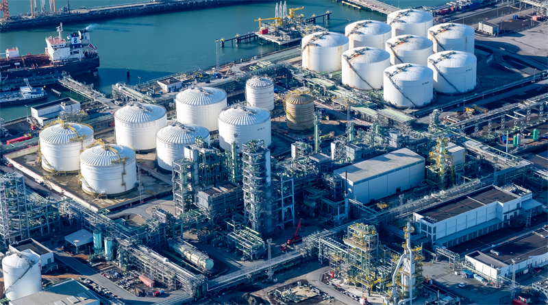 aerial photo of refinery plant in Rotterdam, near water with white storage tanks